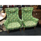 A pair of high backed armchairs in fern print