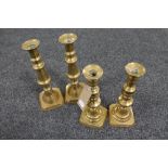 Two pairs of antique brass candlesticks