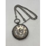 A large antique silver pocket watch with silver dial on heavy antique silver Albert chain