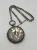 A large antique silver pocket watch with silver dial on heavy antique silver Albert chain