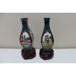 A pair of Japanese cloisonne vases depicting Geisha on circular wooden stands