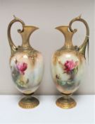 A pair of Royal Worcester gilded ewers hand-painted by R.H.