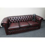 A red oxblood buttoned leather Chesterfield three seater settee