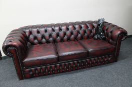 A red oxblood buttoned leather Chesterfield three seater settee