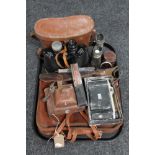 A tray of leather vintage satchel, cameras, case, binoculars,