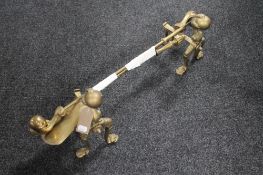 A pair of Victorian brass fire dogs and two brass companion pieces with claw handles