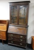 An oak Arts and Crafts bureau bookcase with leaded glass doors