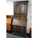 An oak Arts and Crafts bureau bookcase with leaded glass doors