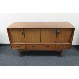 A mid century teak low sideboard fitted with cupboards and drawers