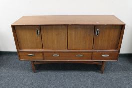 A mid century teak low sideboard fitted with cupboards and drawers