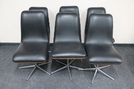 A set of six mid century black vinyl swivel dining chairs on chrome bases