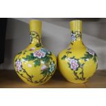 A pair of glazed ceramic bulbous Chinese style vases with pink flowers,