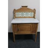 An Edwardian oak tiled back and marble topped washstand