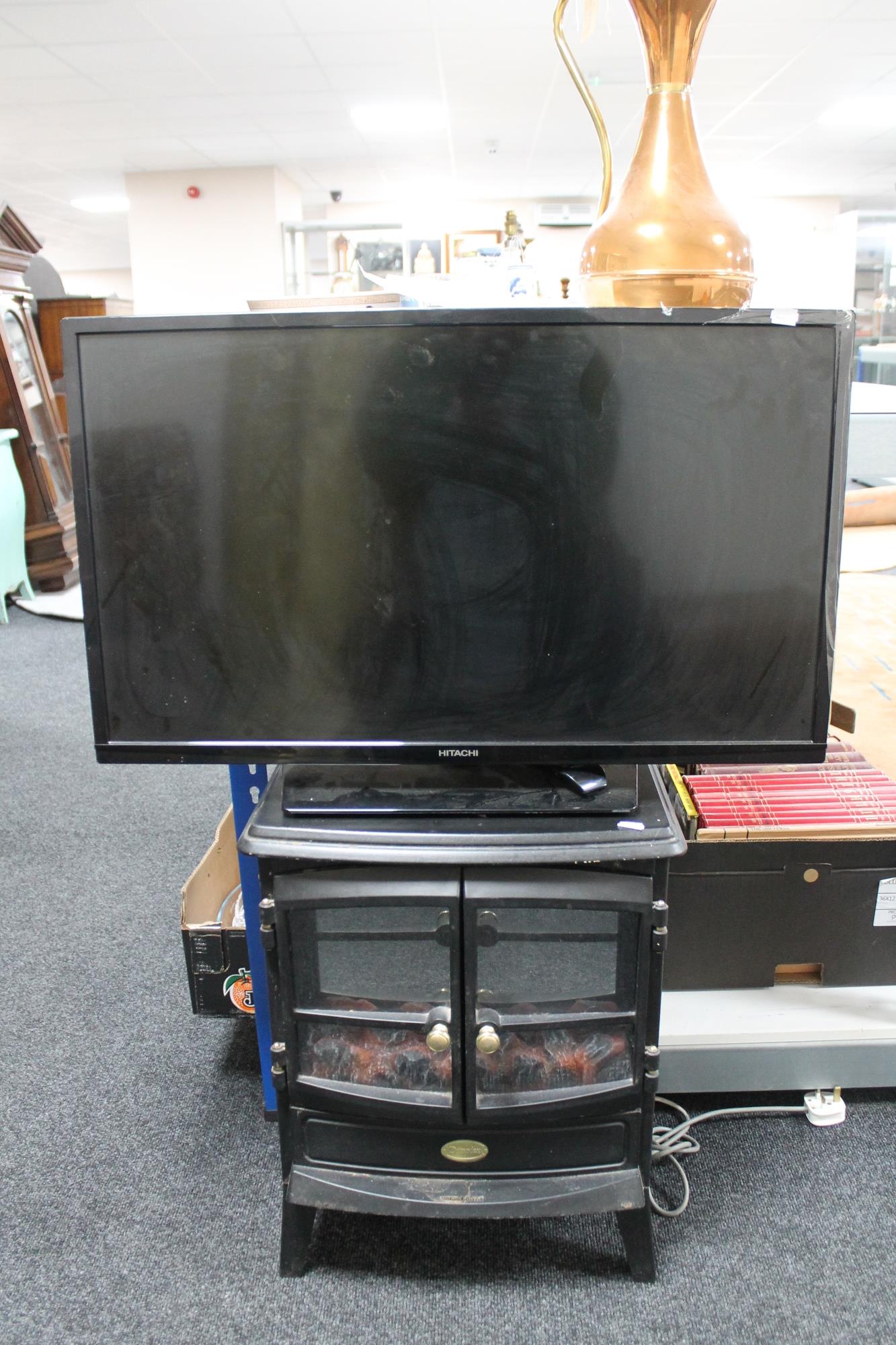 A Hitachi 32" LCD TV with remote together with a Dimplex coal-effect electric fire