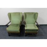 A pair of mid century wingback armchairs in green fabric