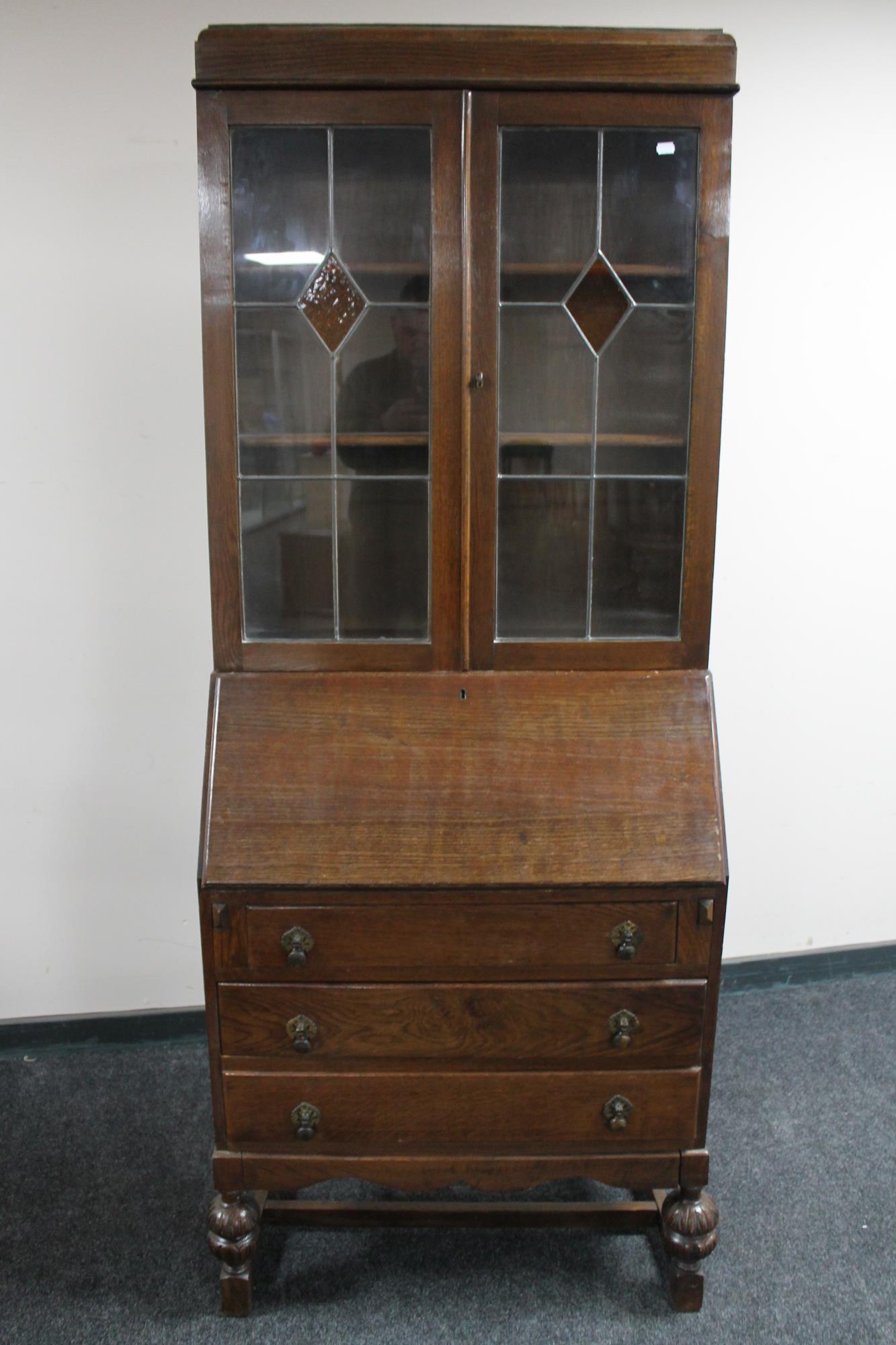 An early 20th century oak leaded glass door bureau bookcase
