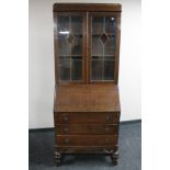 An early 20th century oak leaded glass door bureau bookcase