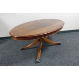 An oval inlaid mahogany pedestal coffee table