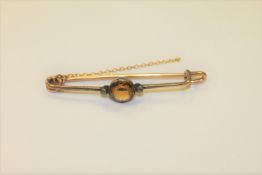 An antique bar brooch set with a citrine and rose cut diamonds