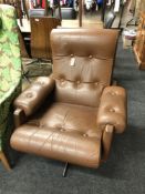 A mid century brown buttoned leather swivel chair on chrome base