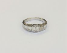 An 18ct white gold five stone emerald-cut diamond ring, the total diamond weight estimated at 1.