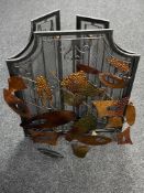 A metal three-way folding fire screen together with a piece of metal wall art