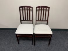 A pair of contemporary folding rail backed dining chairs