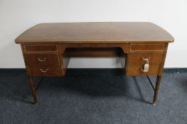 A mid century walnut writing desk fitted with six drawers