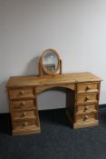A pine kneehole dressing table fitted with eight drawers together with mirror