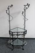 A wrought metal corner two tier occasional table together with a pair of floor standing candle