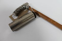 A silver handled walking cane and a vintage pocket cigar roller