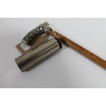 A silver handled walking cane and a vintage pocket cigar roller