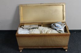 A gold loom blanket box containing vintage linen and bedding