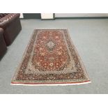 A Persian Keshan rug on red ground 260 cm x 134 cm