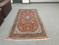 A Persian Keshan rug on red ground 260 cm x 134 cm