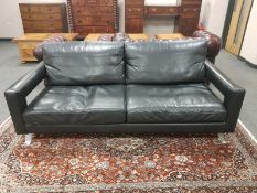 A contemporary black leather and chrome three seater settee,