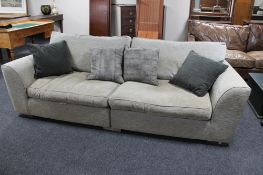 A large three seater settee in beige fabric together with four scatter cushions