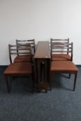 A mid century narrow teak drop leaf table together with four chairs