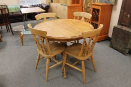 A circular pine kitchen table and four chairs