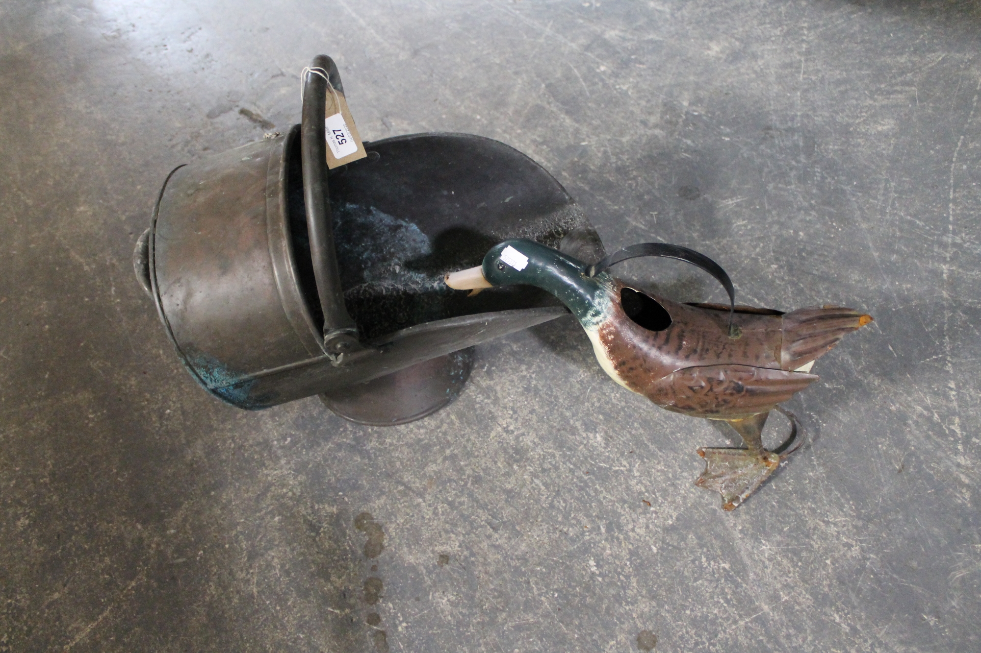 An antique copper coal helmet together with a metal figure of a duck