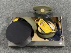 A box containing assorted military hats and a helmet