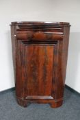 A 19th century continental mahogany corner cupboard