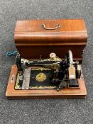 A 20th century cased sewing machine with gilded decoration