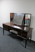 A Stag kneehole dressing table with triple mirror fitted with five drawers