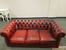 A Chesterfield style Oxblood buttoned leather three seater settee,