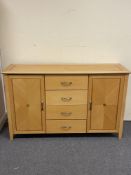 A beech double door sideboard fitted four drawers