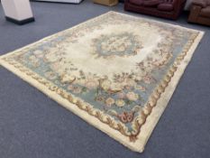 A large cream floral Chinese style fringed carpet,