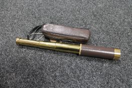 A brass and leather cased pocket telescope in carry case