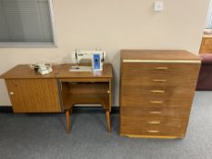 A mid 20th century teak seven drawer chest and New Home electric sewing machine in teak cabinet