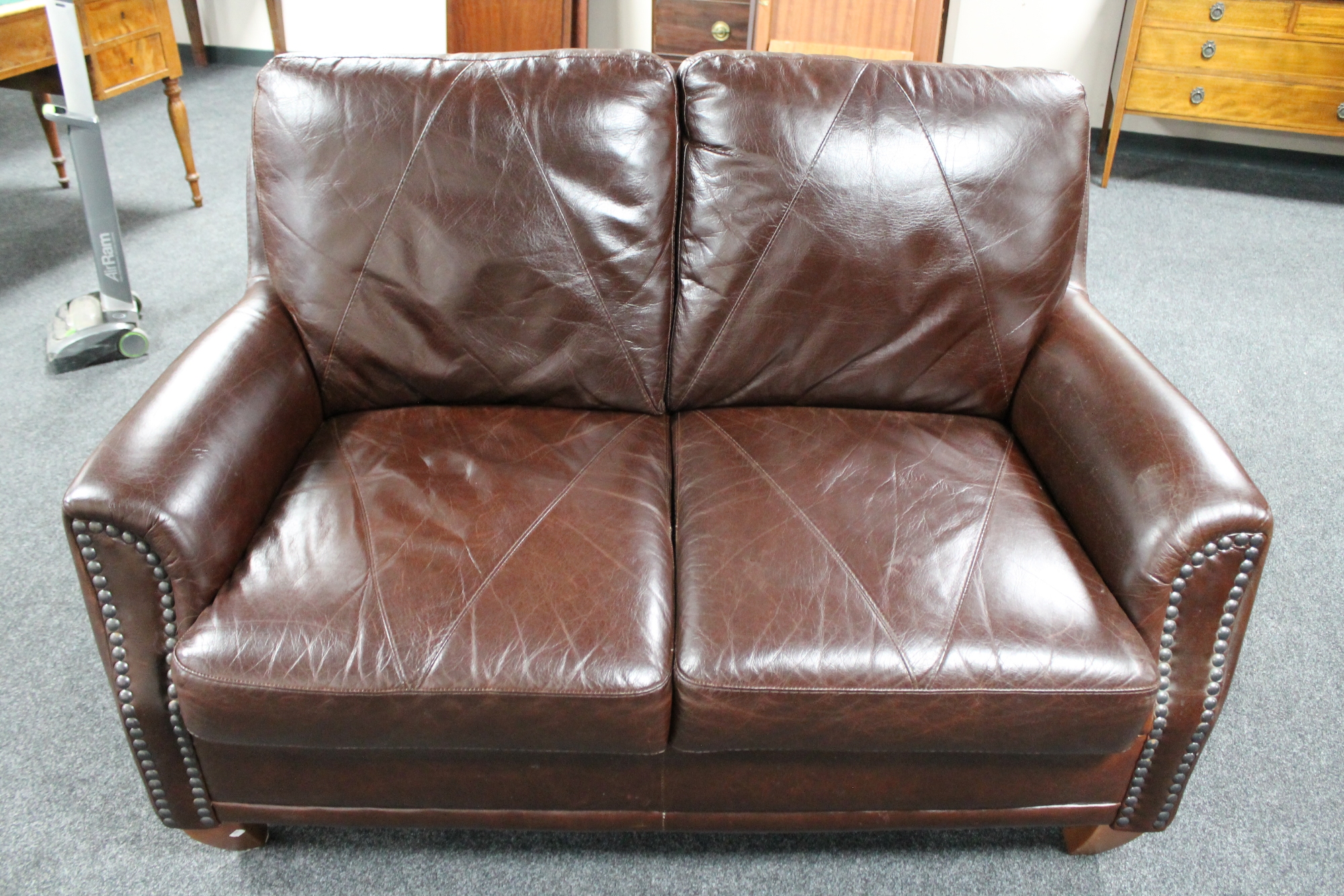 A brown buttoned leather two seater settee